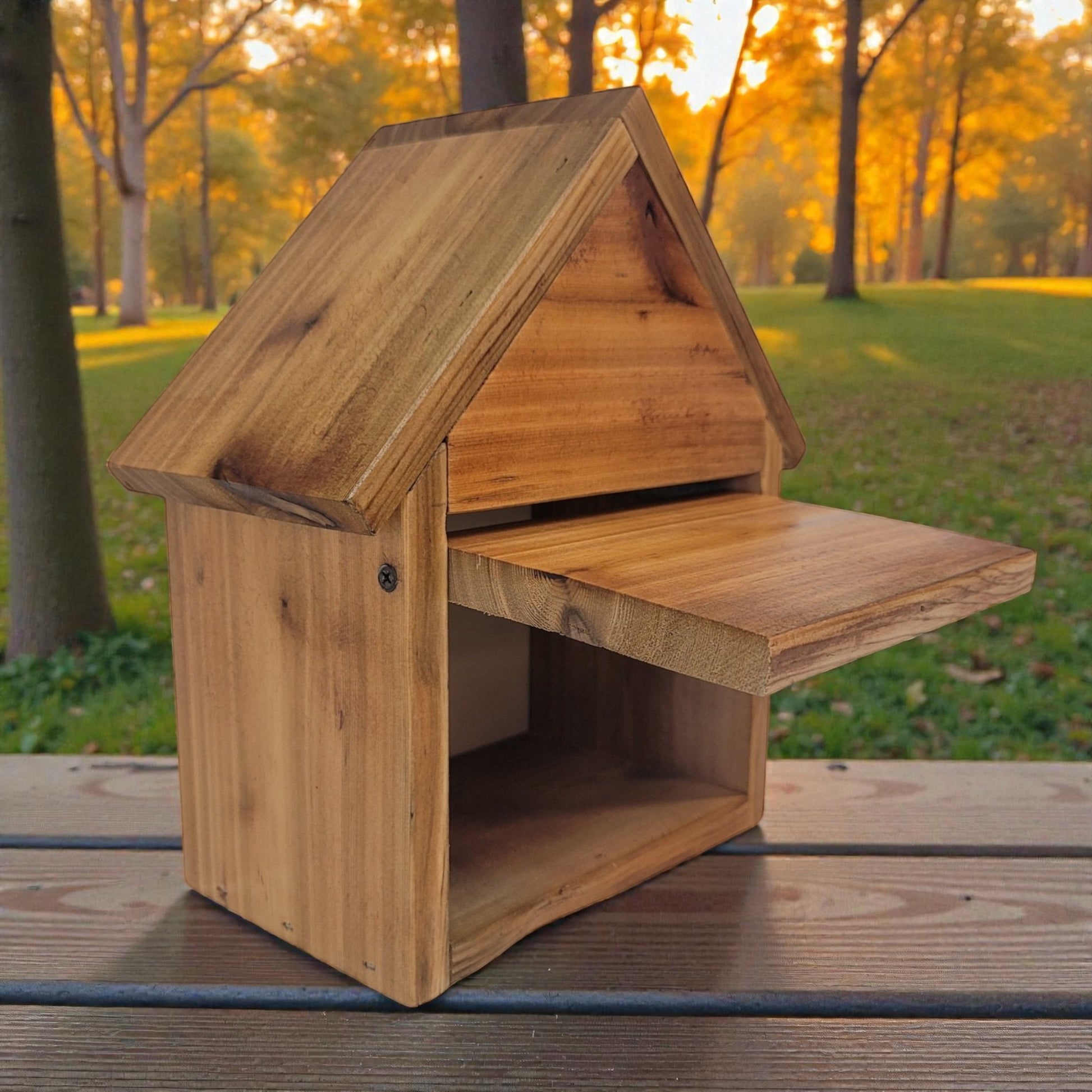Wooden birdhouse on a wooden surface with a park background