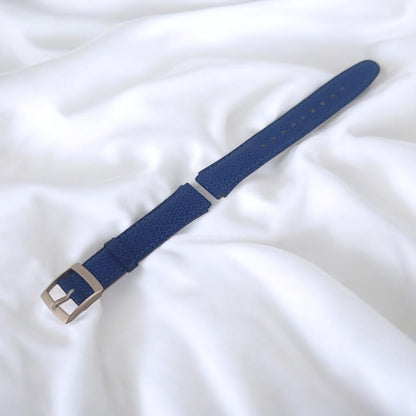 Blue watch strap with silver buckle on a white background