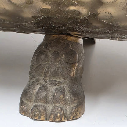 Ornate brass fireplace log holder with lion heads and paw feet

