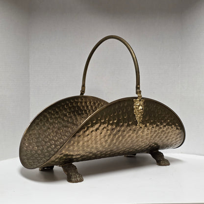 Ornate brass fireplace log holder with lion heads and paw feet
