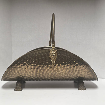 Ornate brass fireplace log holder with lion heads and paw feet
