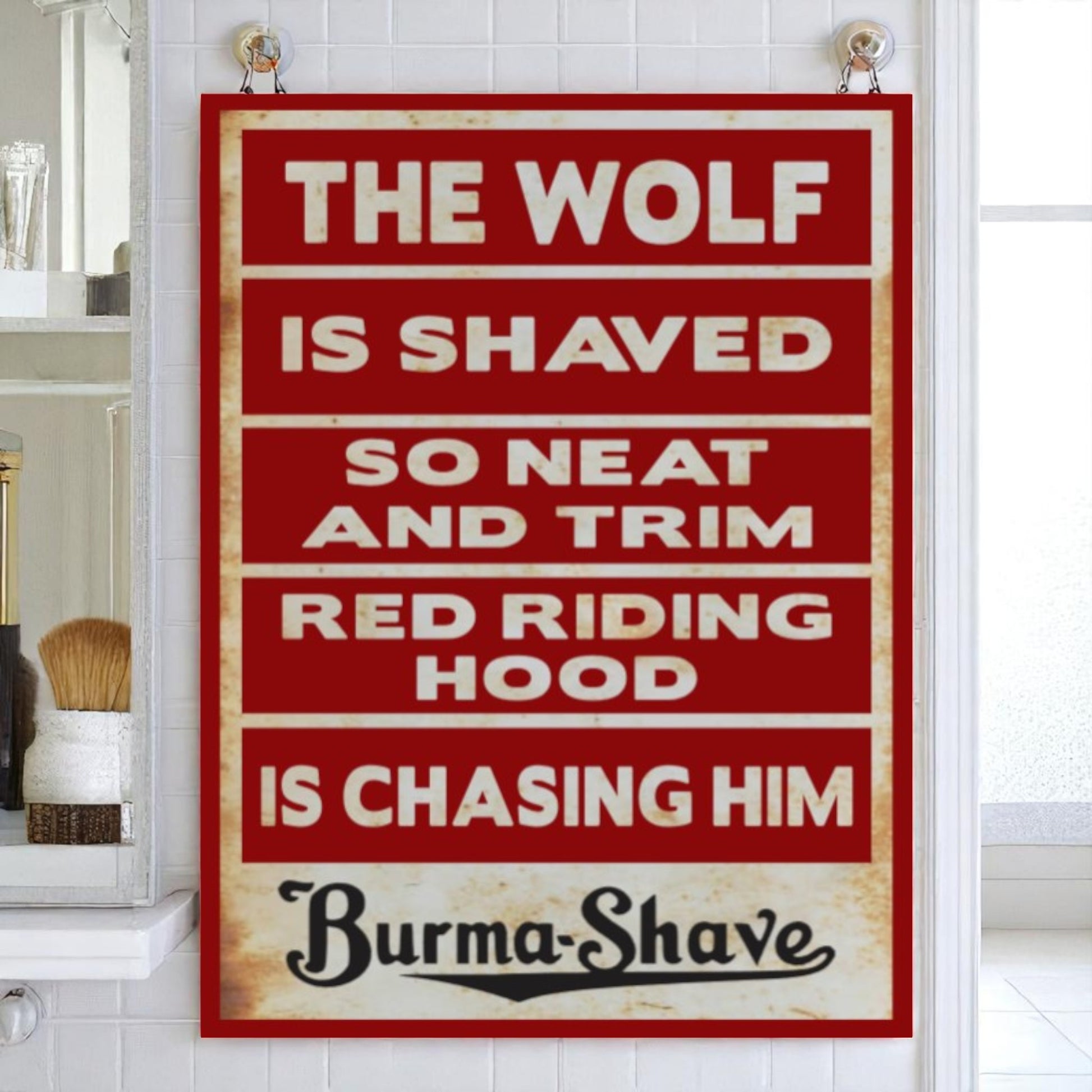 Vintage-style sign with text about 'The Wolf' and 'Red Riding Hood' from Burma-Shave brand, displayed in a bathroom.