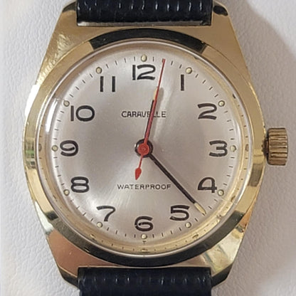 Wristwatch with gold case and black strap on a white background