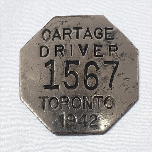 Metallic octagonal tag with text 'Cartage Driver 1567 Toronto 1942' on a white background