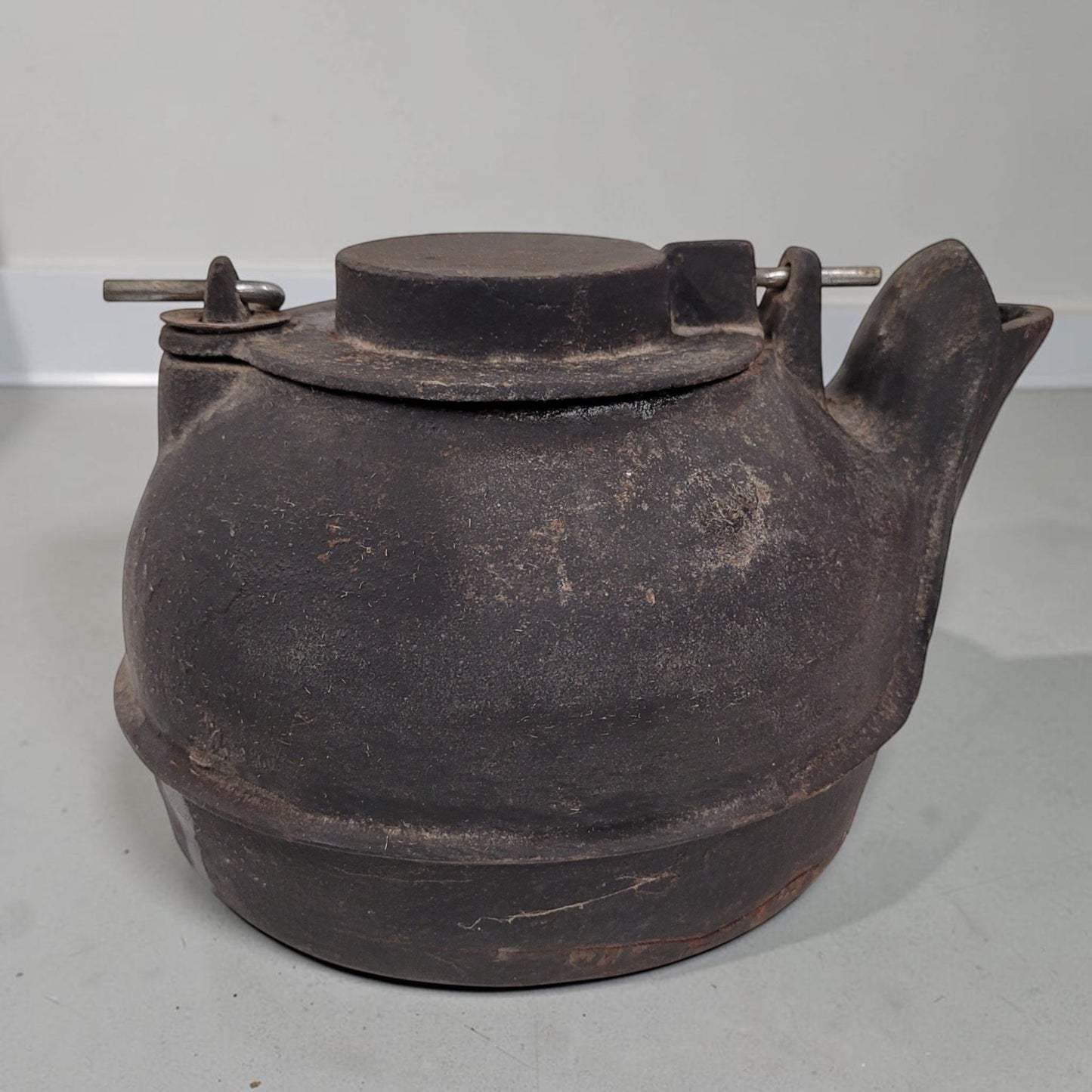 Vintage No. 16 cast iron kettle with swing lid for wood stove humidifying and rustic décor.
