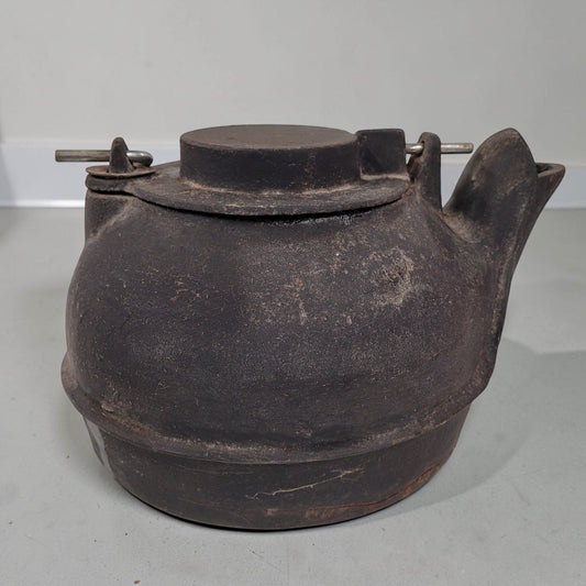 Vintage No. 16 cast iron kettle with swing lid for wood stove humidifying and rustic décor.
