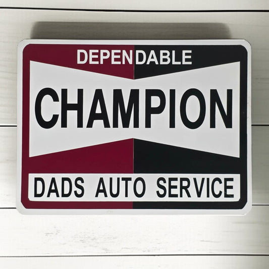 Metal sign with 'Dependable Champion Dads Auto Service' text on a wooden background