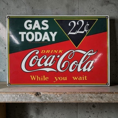 Vintage-style Coca-Cola sign on a wooden surface with a concrete wall background