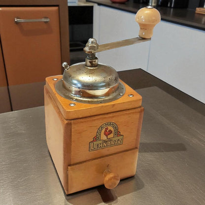 Wooden coffee grinder with metal top on a kitchen counter