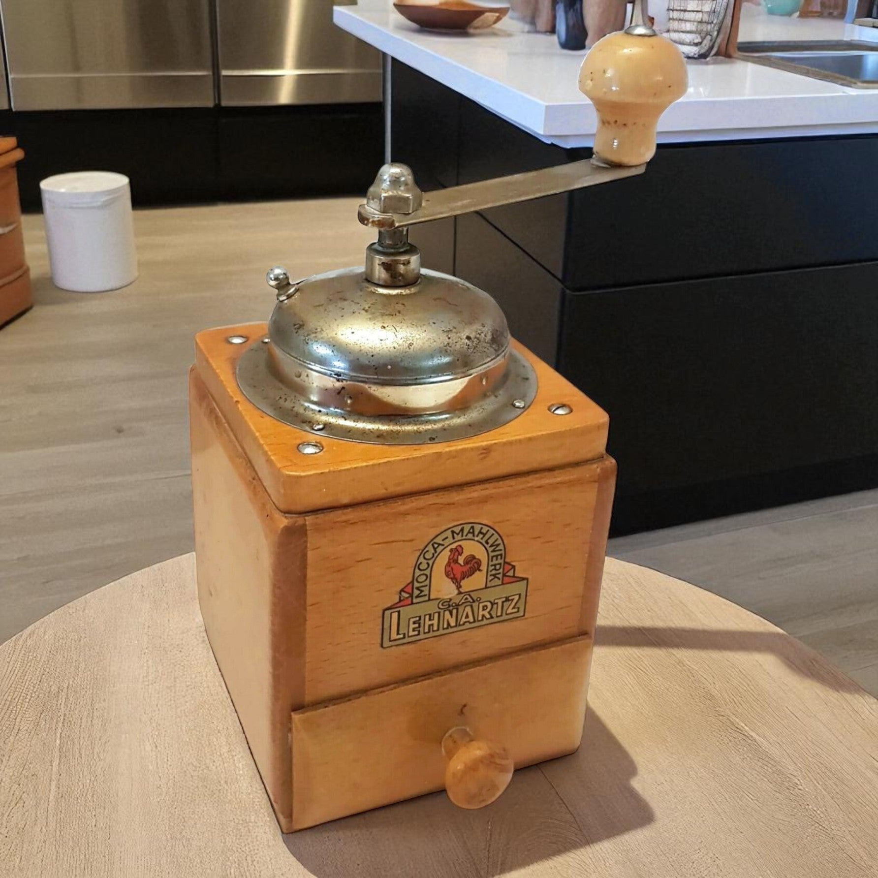 Wooden coffee grinder with metal top on a kitchen counter