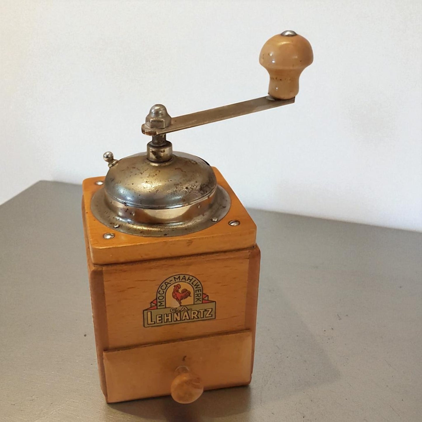 Vintage wooden coffee grinder with brass top on a white background