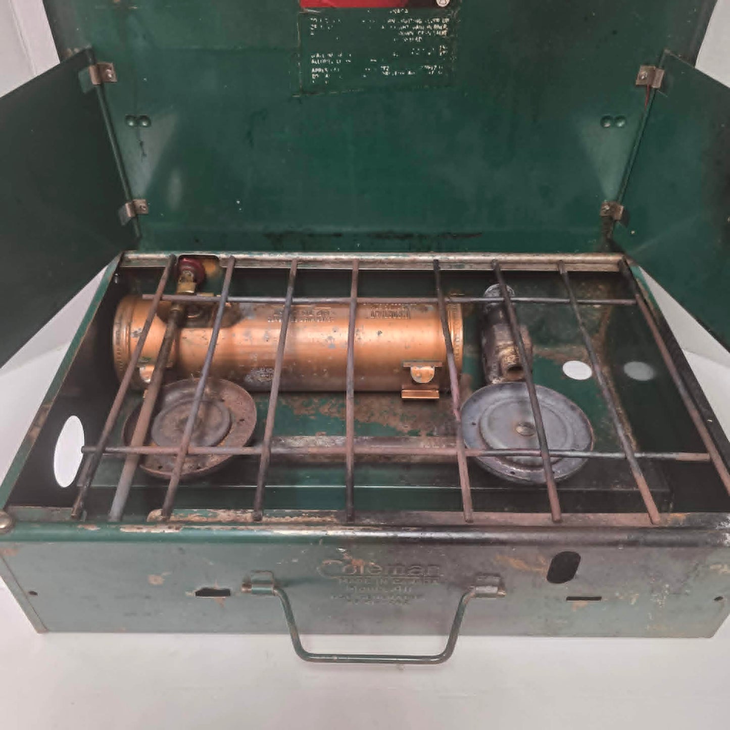 Vintage Coleman Model 411 Canadian suitcase camp stove with copper-colored fuel tank.

