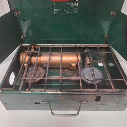 Vintage Coleman Model 411 Canadian suitcase camp stove with copper-colored fuel tank.
