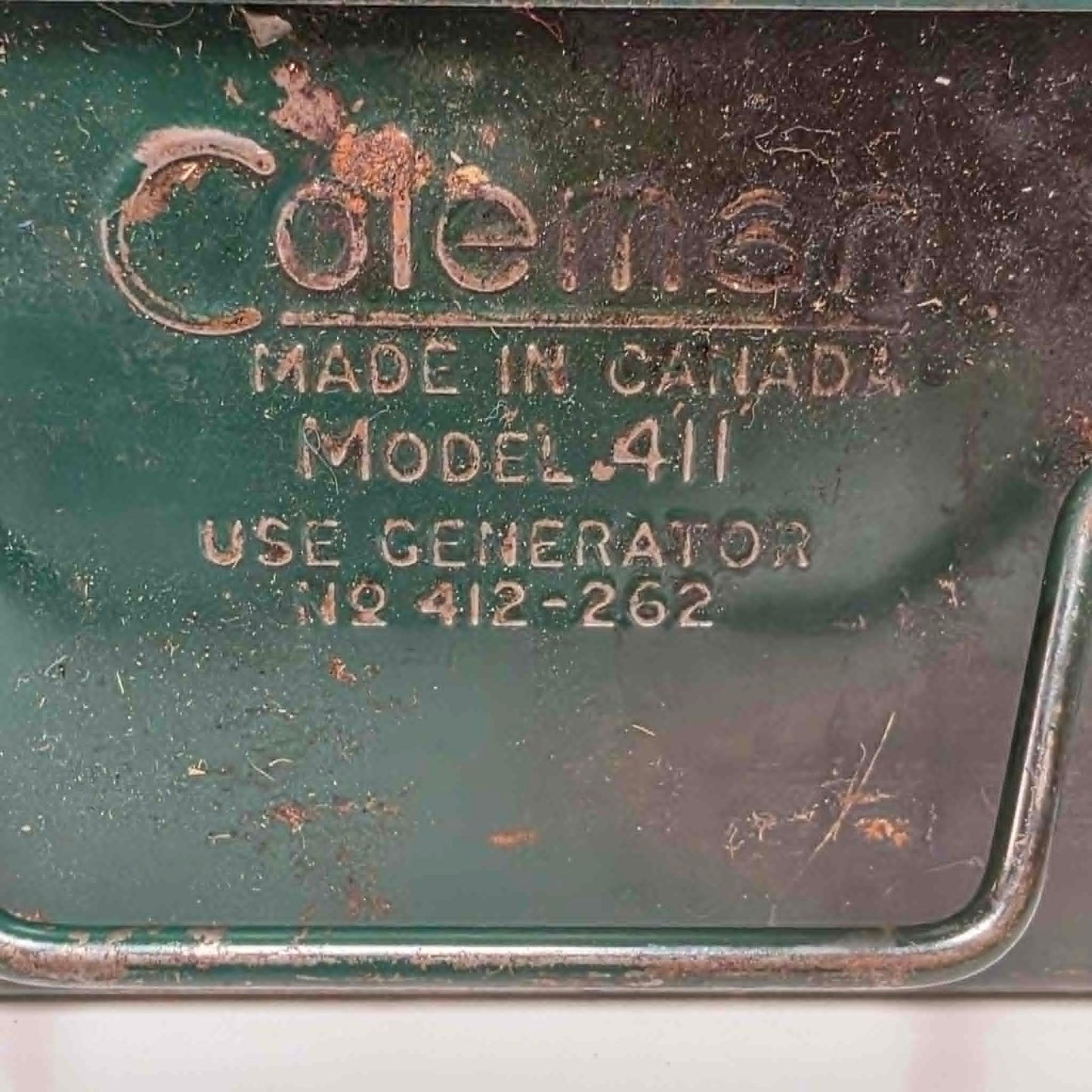 Vintage Coleman Model 411 Canadian suitcase camp stove with copper-colored fuel tank.
