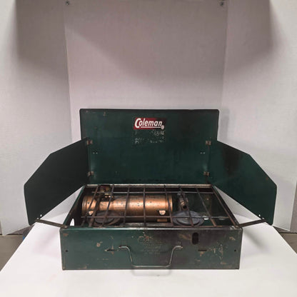 Vintage Coleman Model 411 Canadian suitcase camp stove with copper-colored fuel tank.
