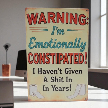 Metal sign with humorous text and graphics on a desk