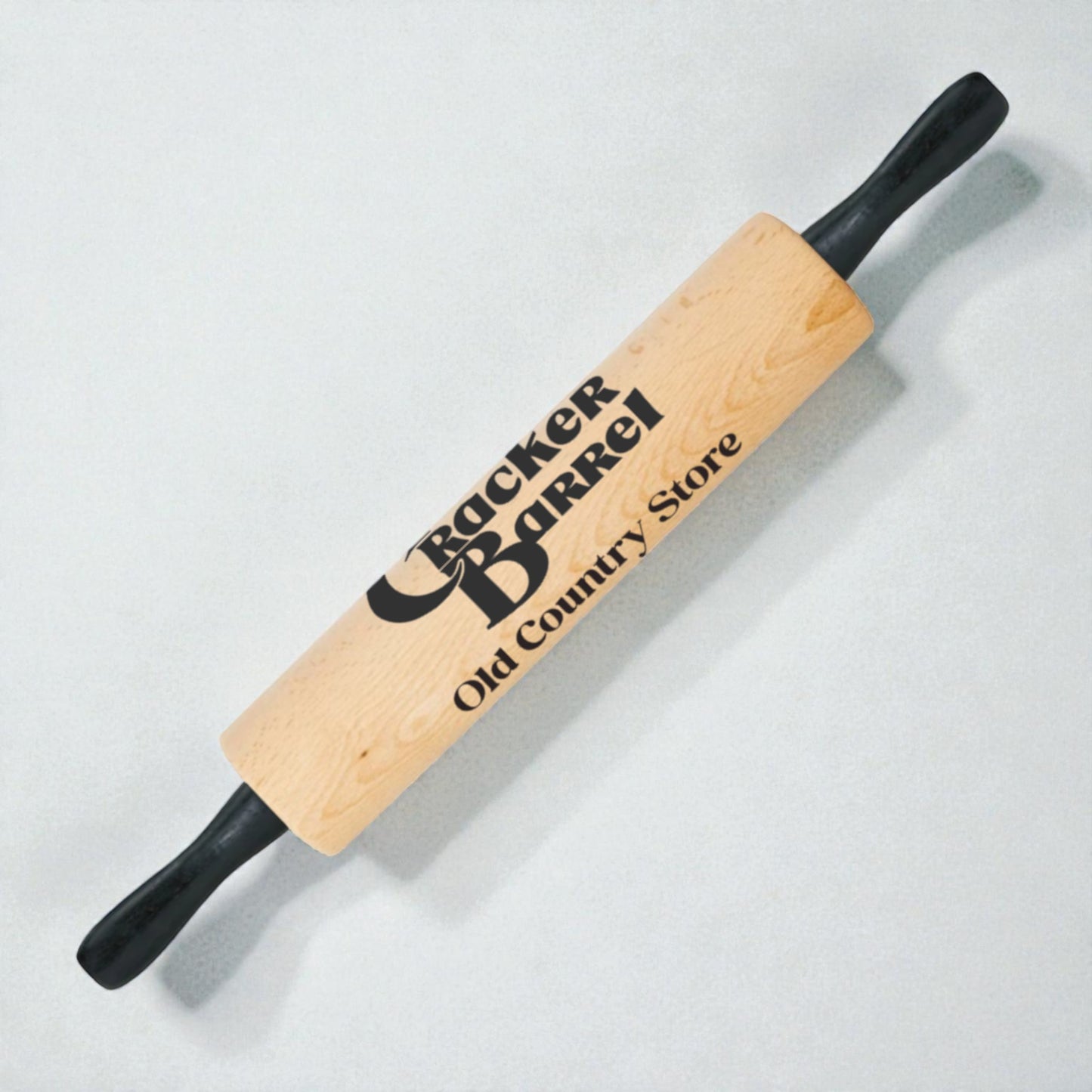 Wooden rolling pin with Cracker Barrel logo on a light gray background
