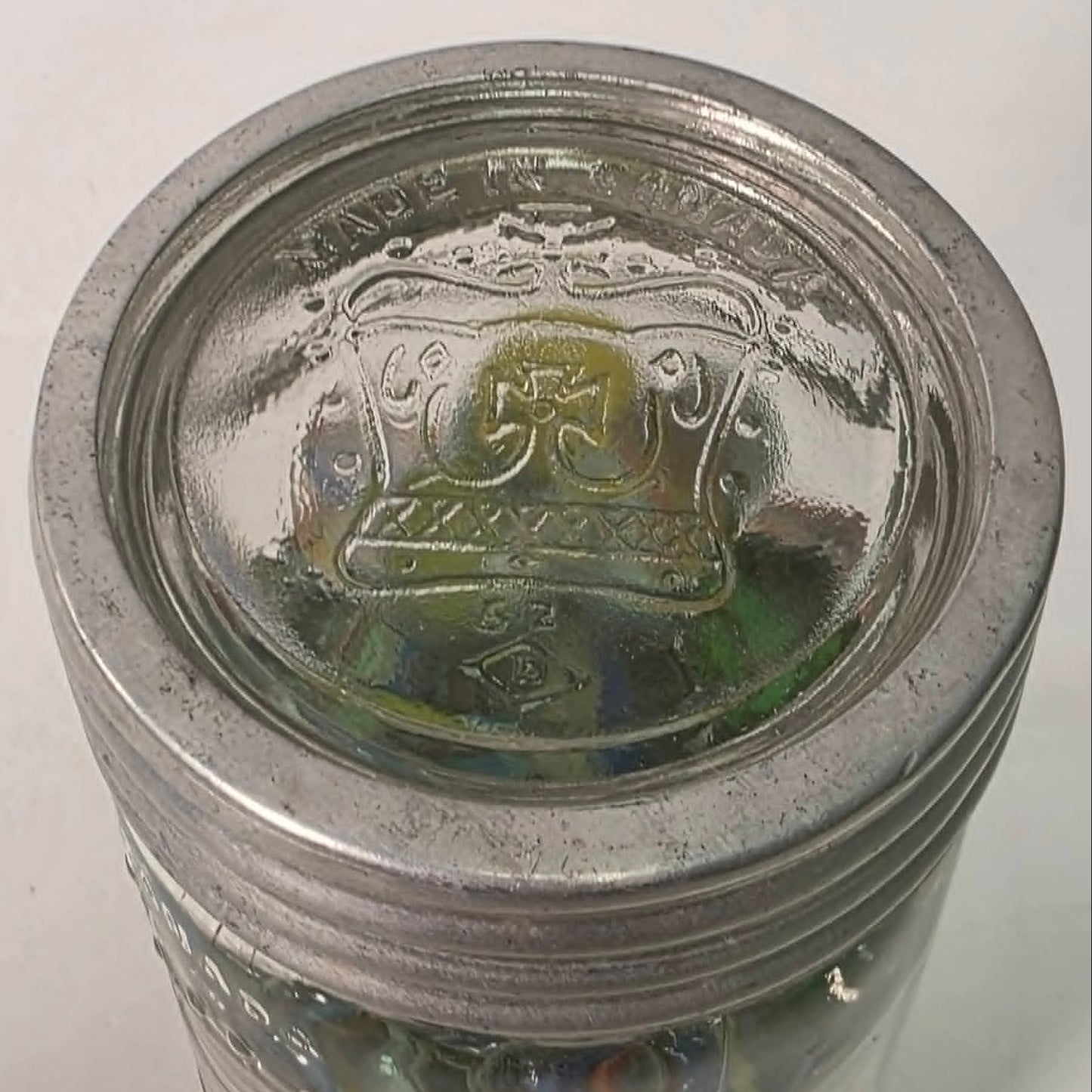 Antique Crown Sealer jar packed with unsorted vintage marbles collected over the years.
