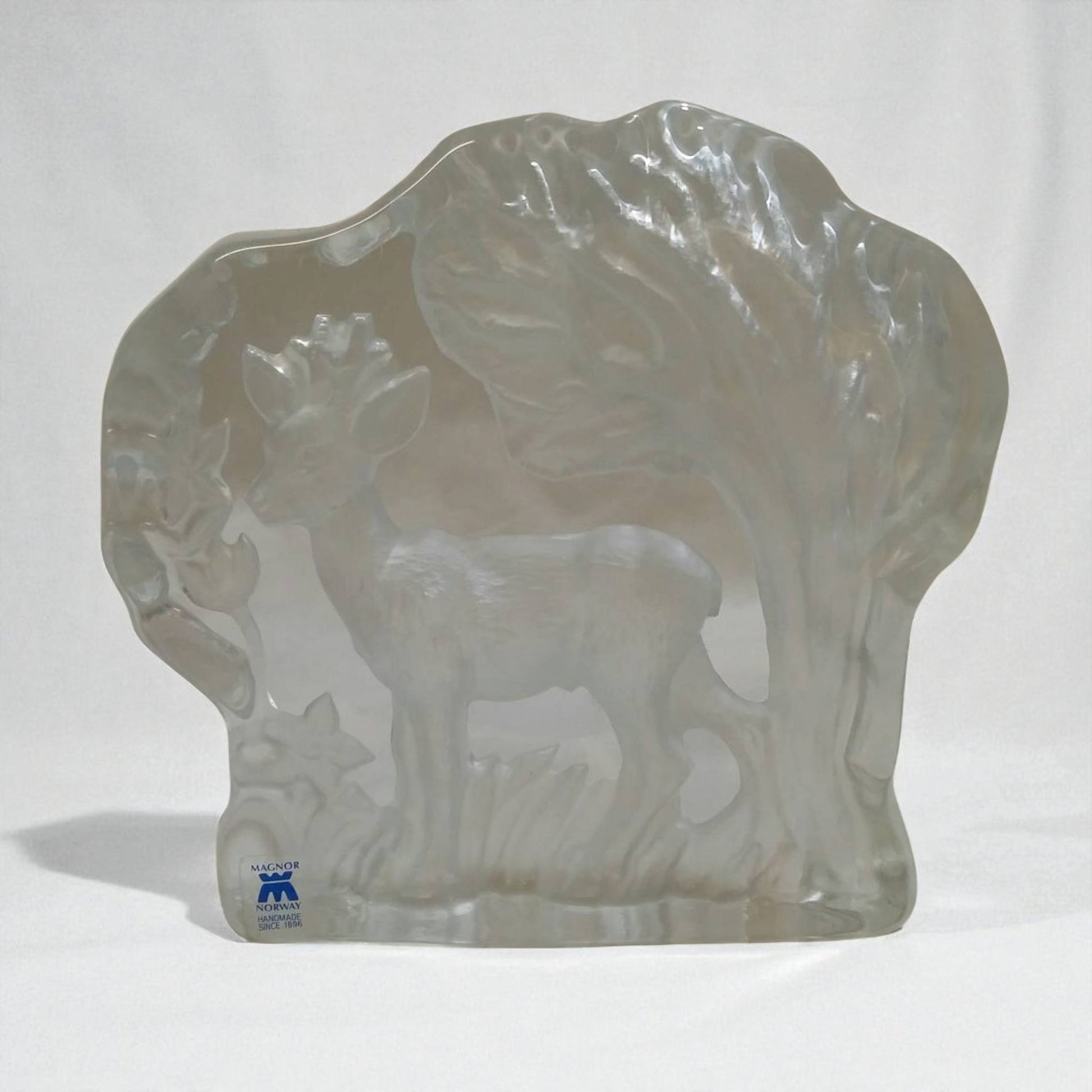 Clear glass sculpture of a deer with a white background