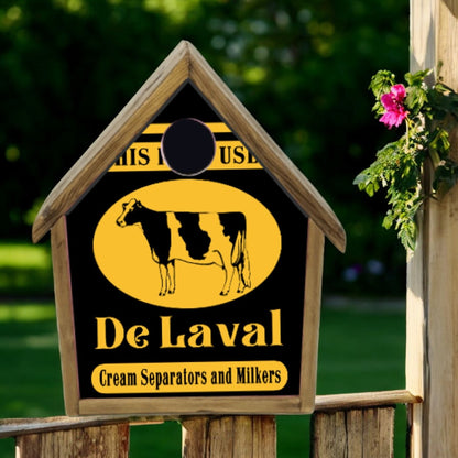 Wooden sign with De Laval logo featuring a cow, set against a blurred natural background.