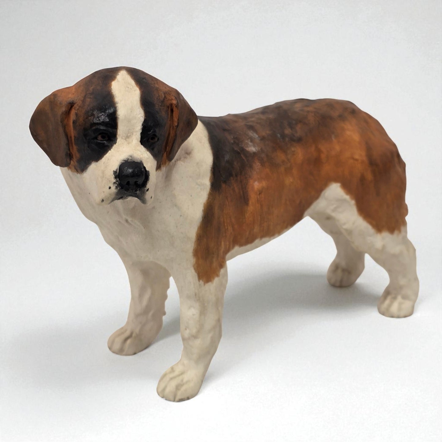 Dog figurine with brown, black, and white coloration on a white background