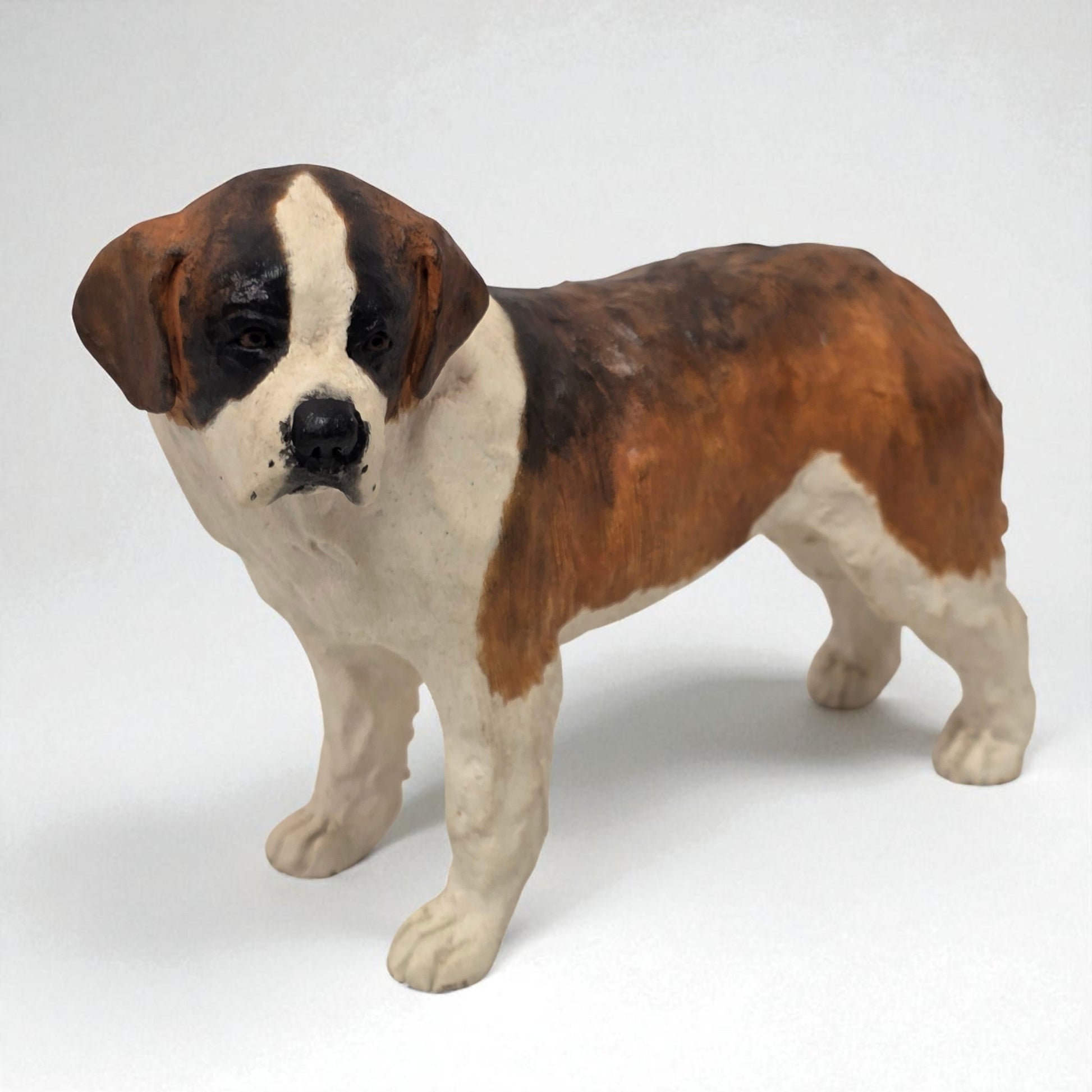 Dog figurine with brown, black, and white coloration on a white background