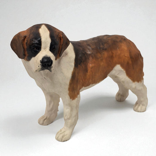 Dog figurine with brown, black, and white coloration on a white background
