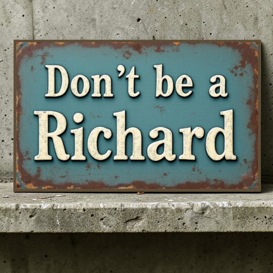 Rustic metal sign with text 'Don't be a Richard' on a concrete surface.