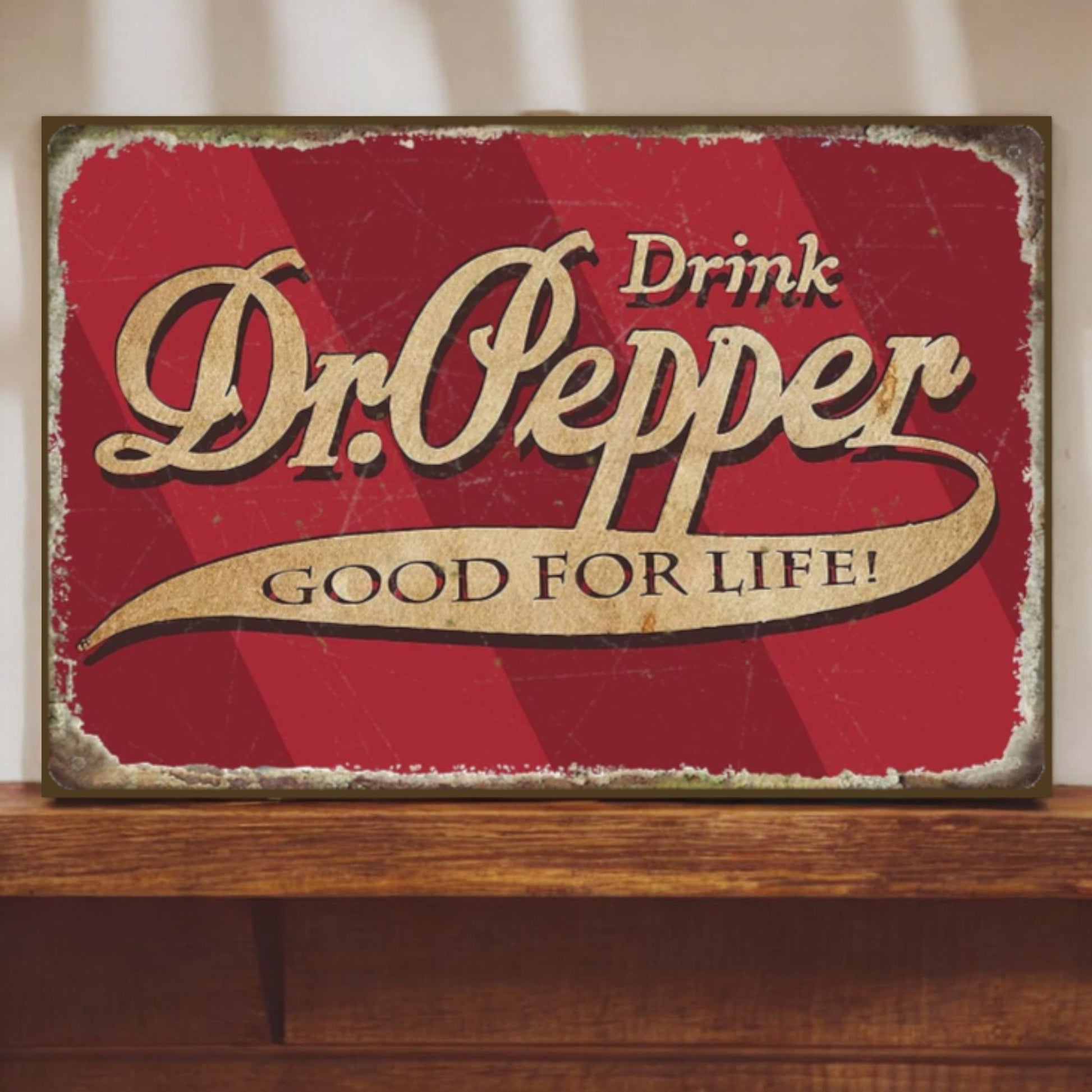 Vintage-style Dr. Pepper sign with red background and gold text on a wooden surface.