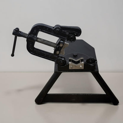 Erie Tools heavy duty pipe vise mounted on stand used for industrial plumbing and pipe clamping work.