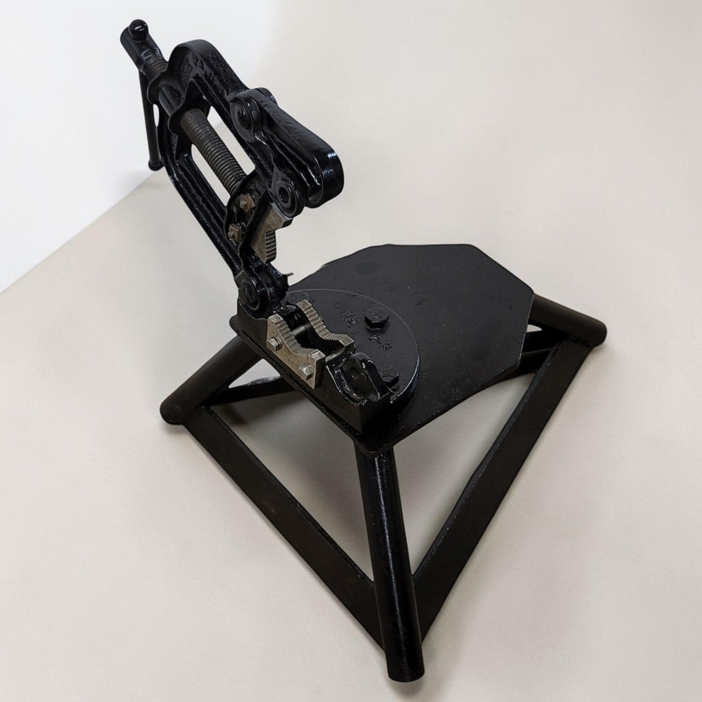Erie Tools heavy duty pipe vise mounted on stand used for industrial plumbing and pipe clamping work.