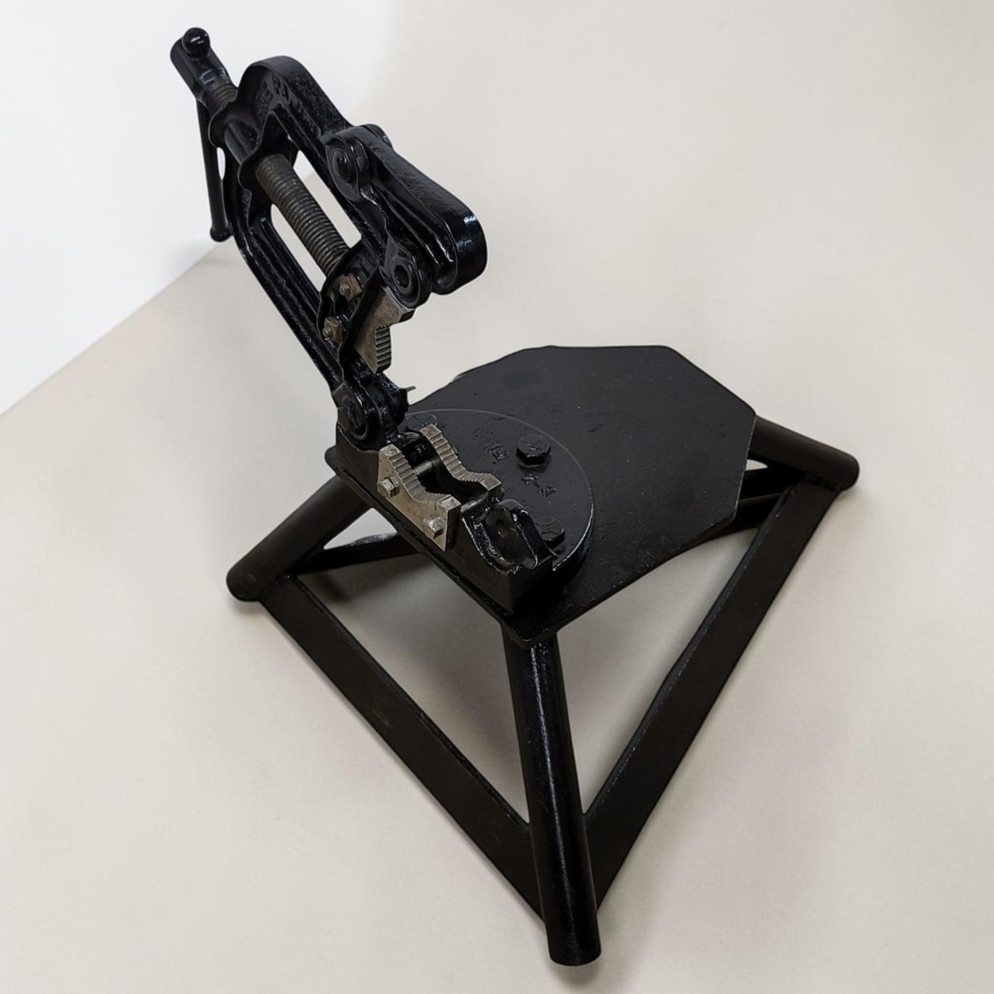 Erie Tools heavy duty pipe vise mounted on stand used for industrial plumbing and pipe clamping work.