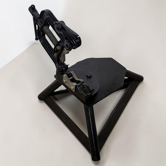 Erie Tools heavy duty pipe vise mounted on stand used for industrial plumbing and pipe clamping work.