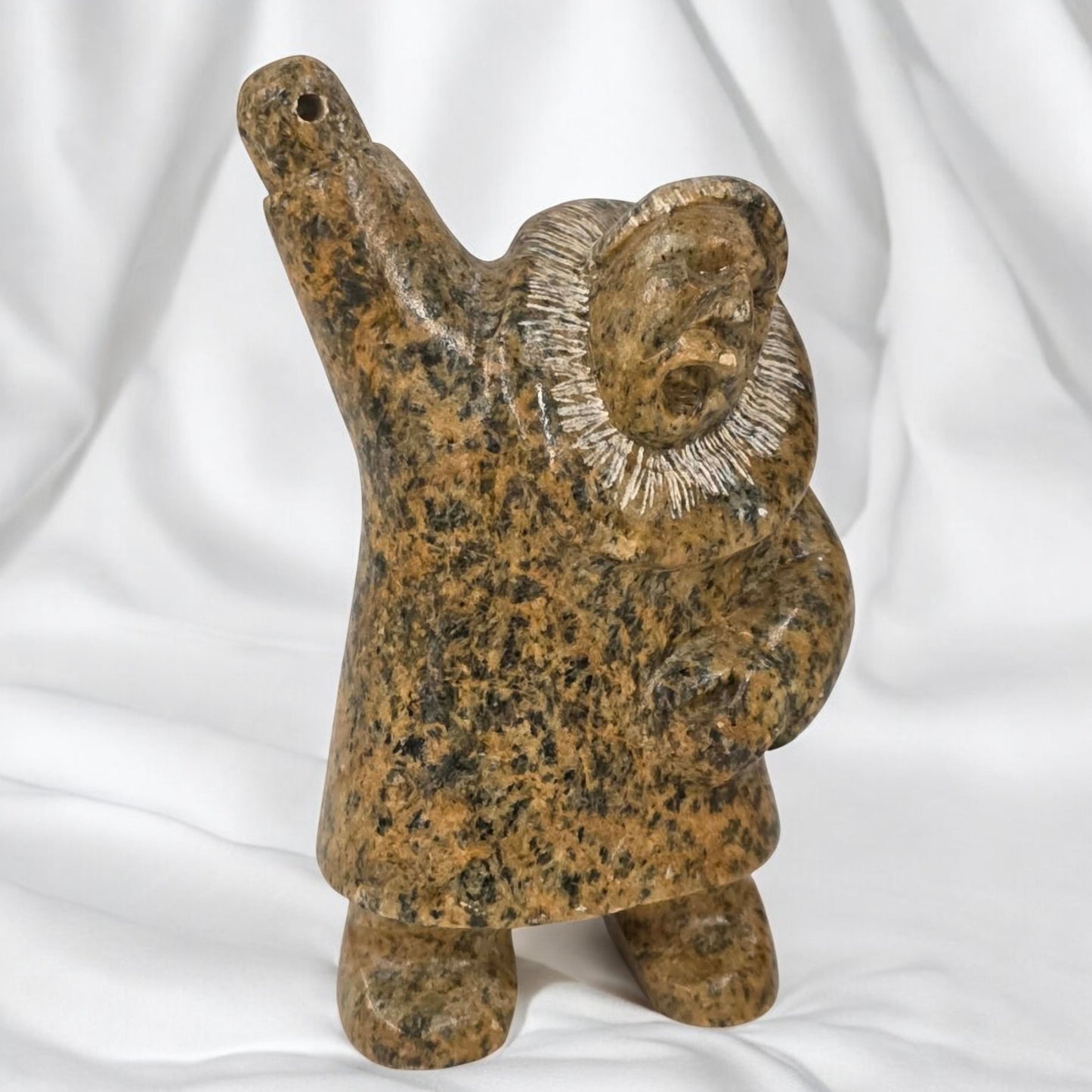 Brown stone sculpture of a figure with raised arm on a white background