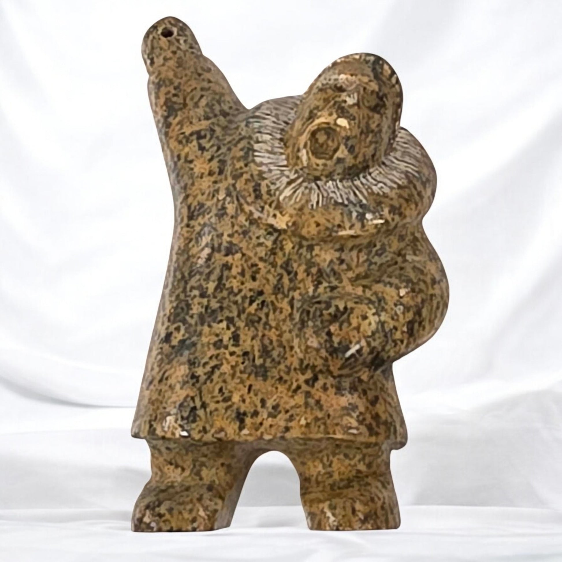 Ceramic sculpture of a figure holding a child on a white background