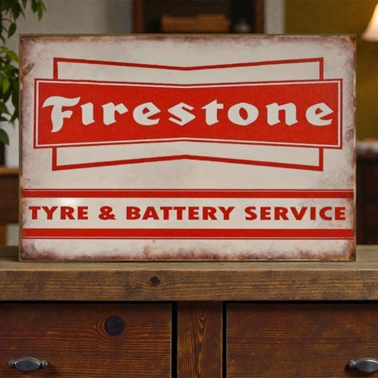 Vintage-style 'Firestone Tyre & Battery Service' sign on a wooden surface.