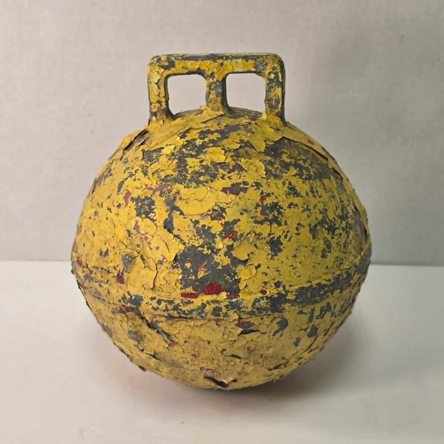 Antique yellow Newfoundland fishing buoy stamped Phillips Trawl Products Ltd., Grimsby England.