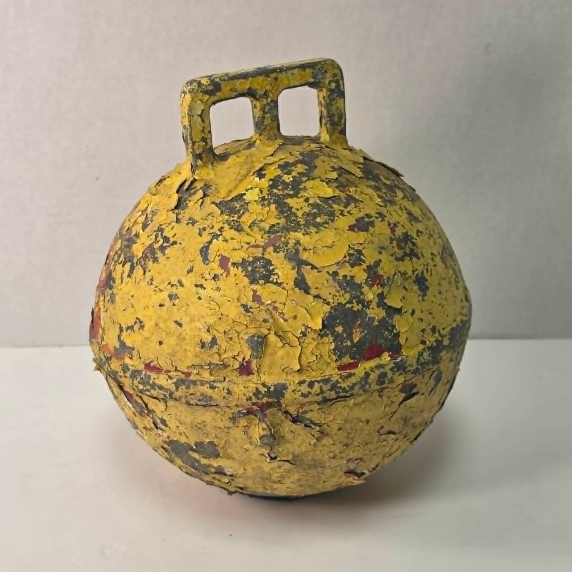 Antique yellow Newfoundland fishing buoy stamped Phillips Trawl Products Ltd., Grimsby England.
