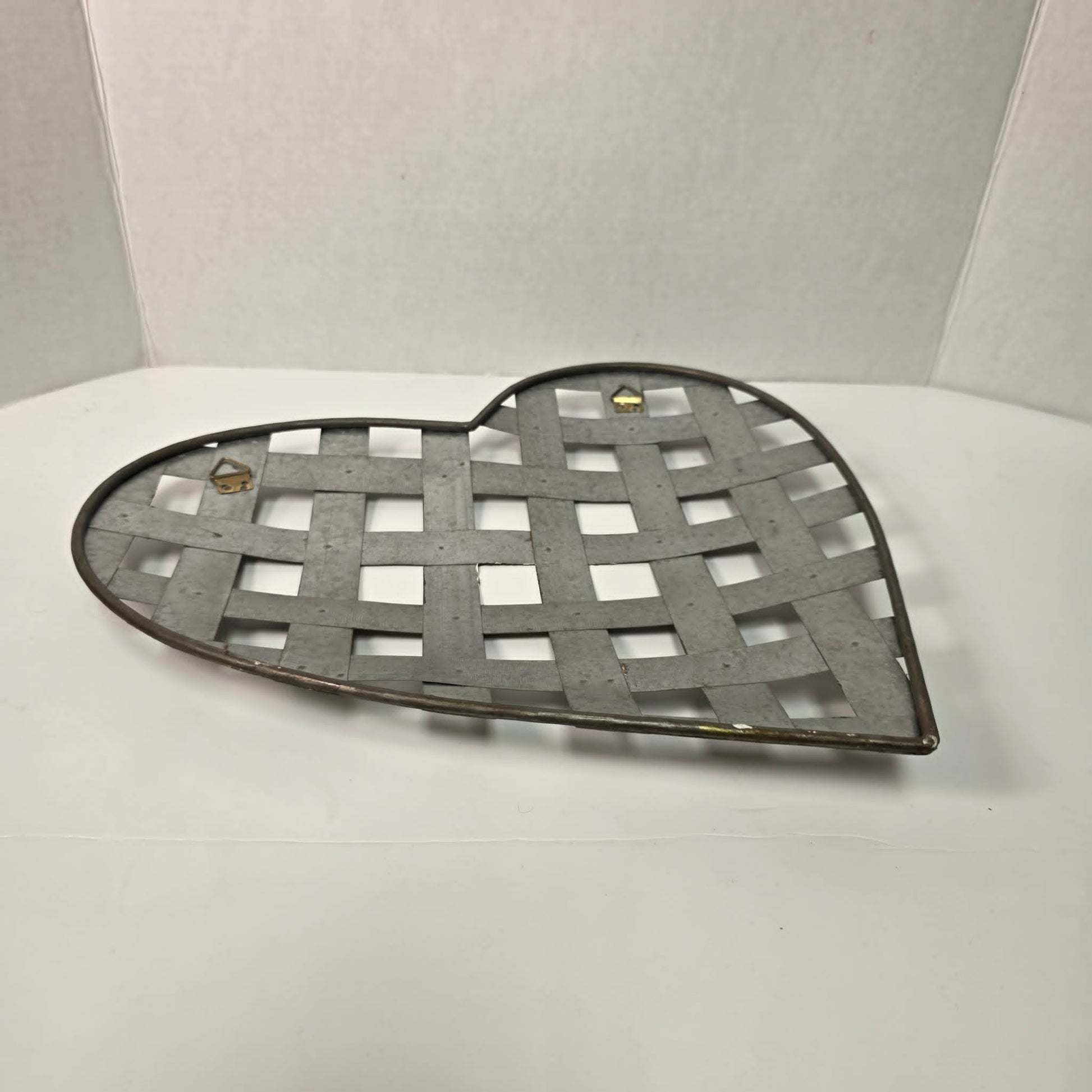 Rustic woven galvanized metal folk art heart wall hanging.