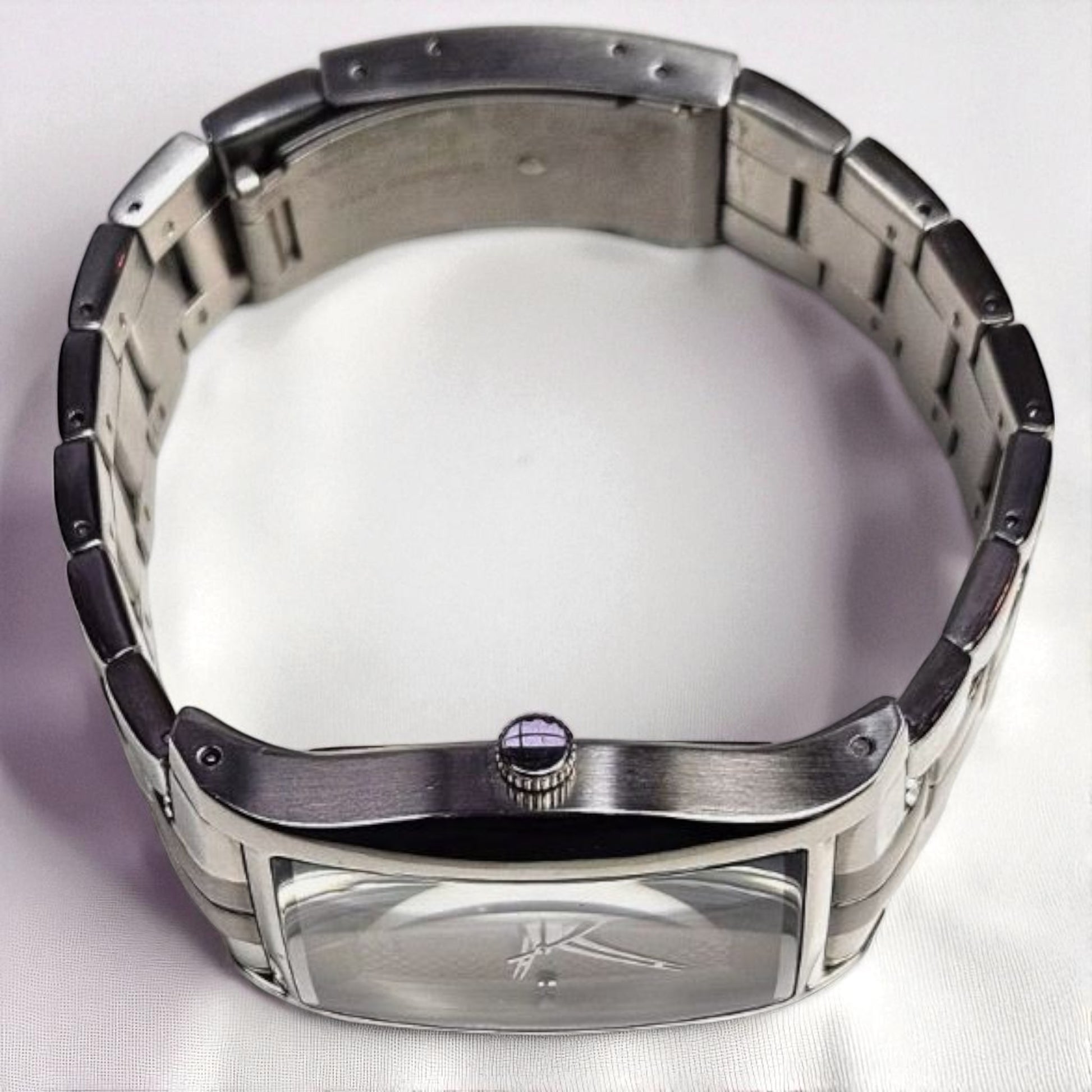 Silver watch with a reflective surface on a white background