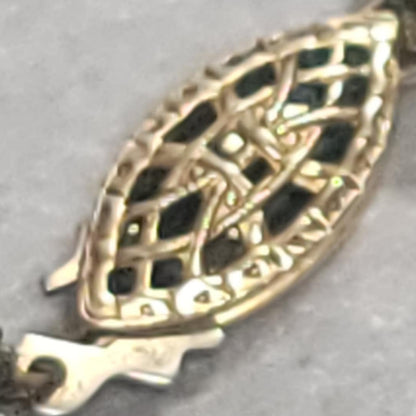 Close-up of a pearl necklace with a decorative clasp on a gray background