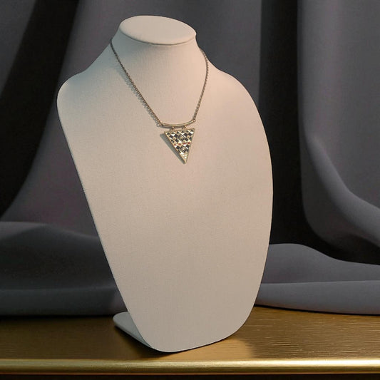 Necklace with a geometric pendant on a white mannequin bust against a dark background