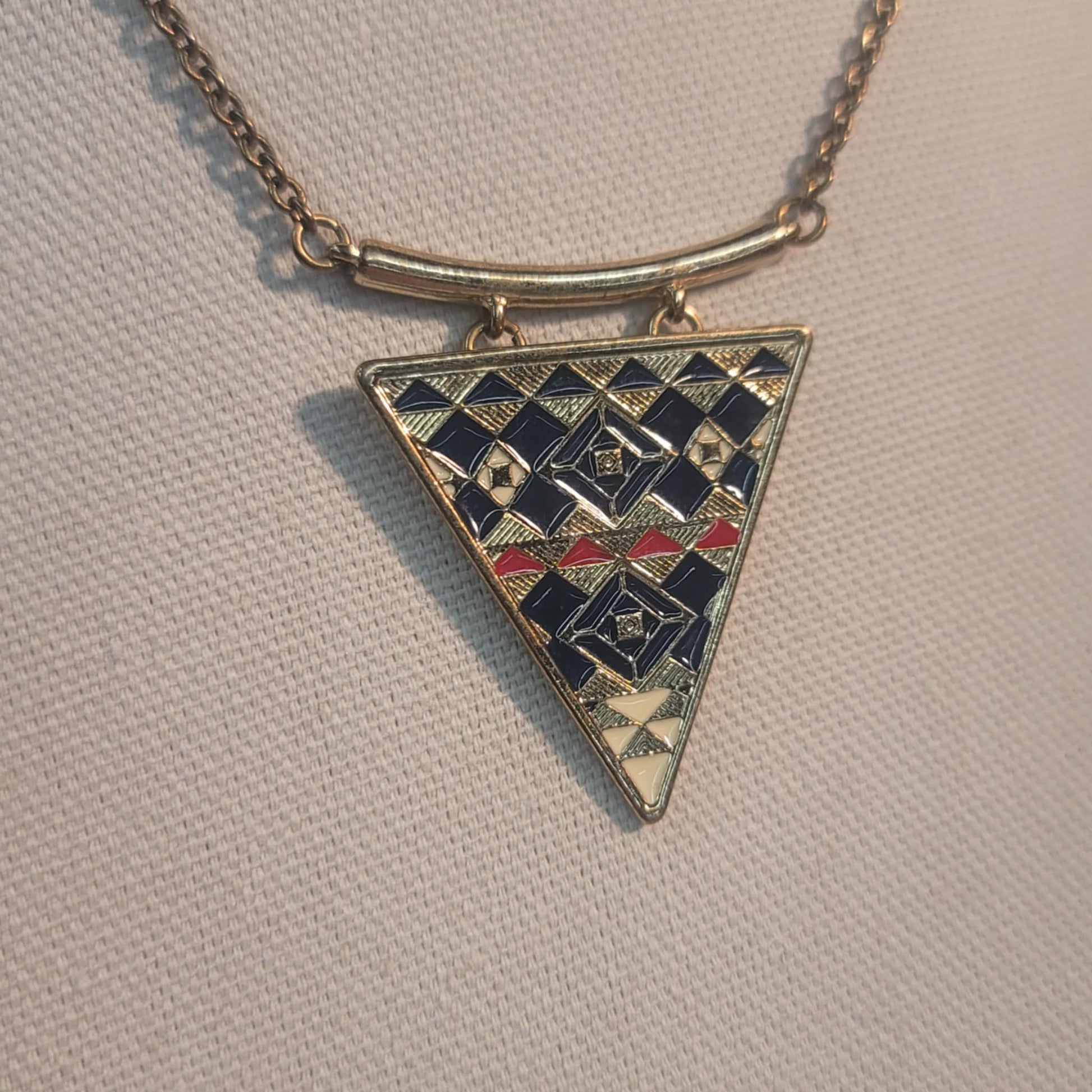 Triangular pendant with geometric pattern on a beige background