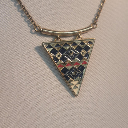 Triangular pendant with geometric pattern on a beige background