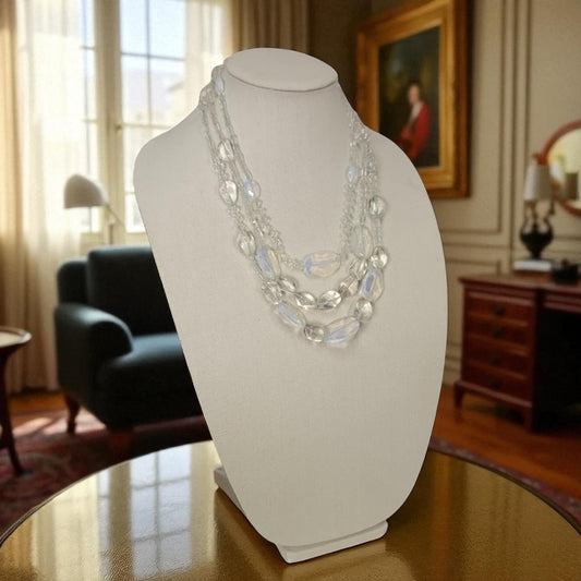 Necklace on a mannequin bust in a room with furniture and decor
