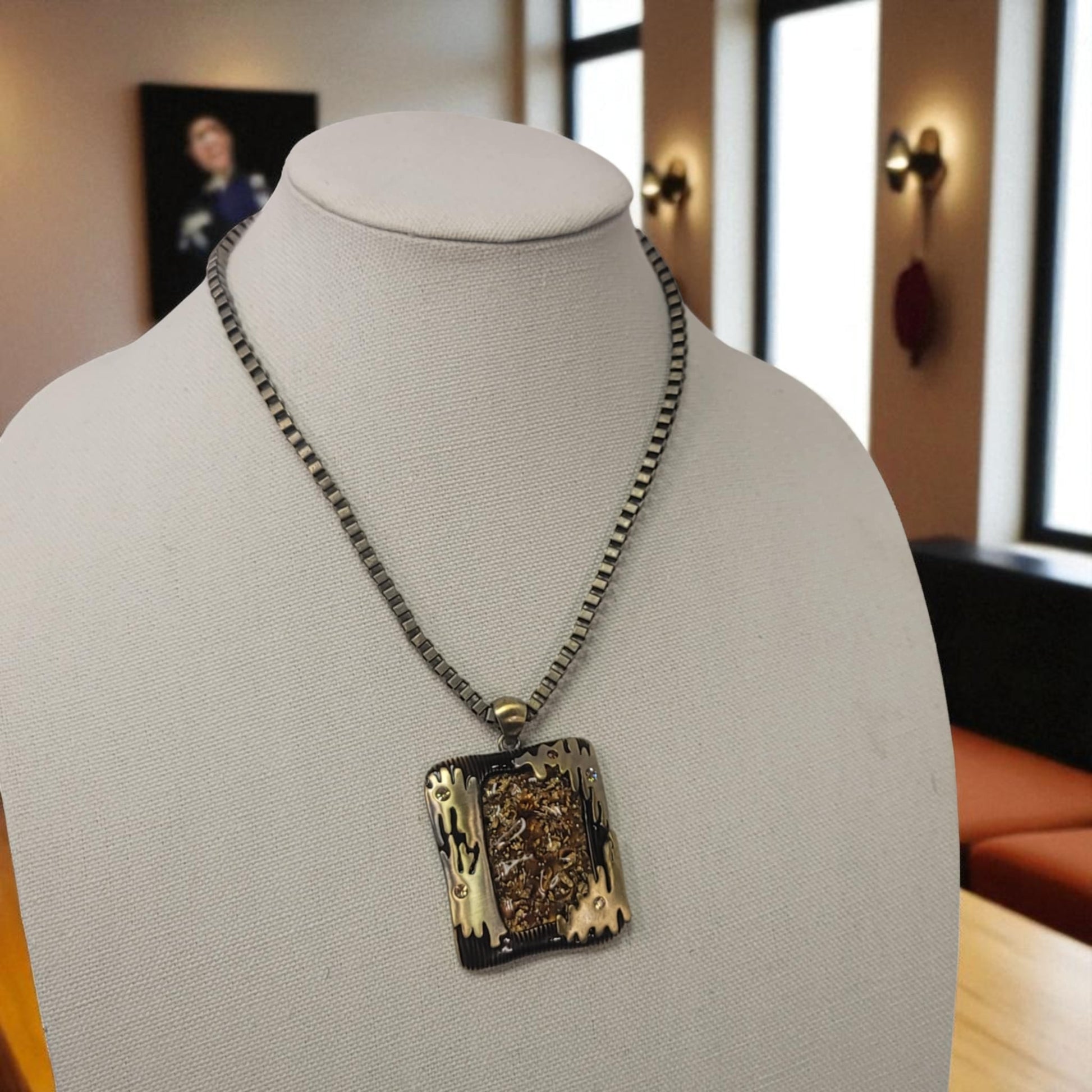 Necklace with a decorative pendant on a mannequin bust in an indoor setting