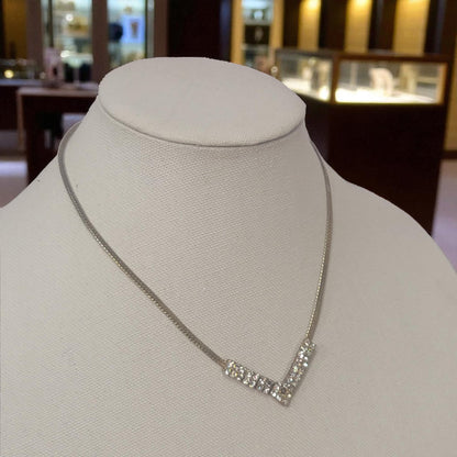 Silver necklace on a mannequin bust in a jewelry store setting