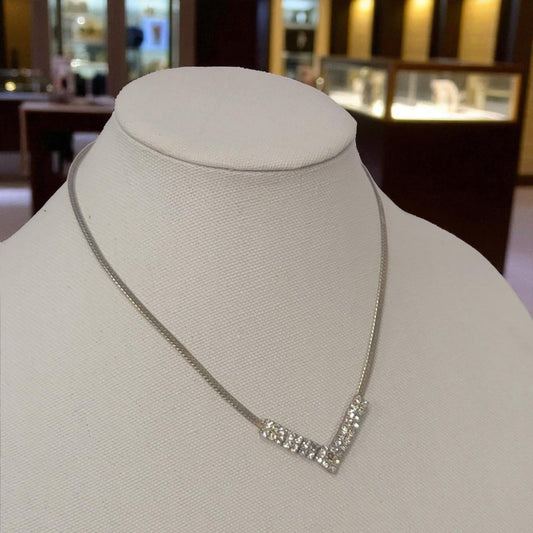 Silver necklace on a mannequin bust in a jewelry store setting
