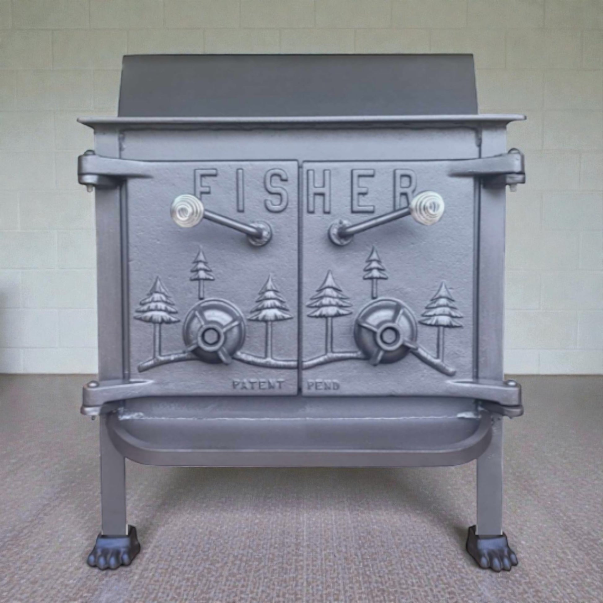 Gray cast iron stove with 'Fisher' branding on a neutral background