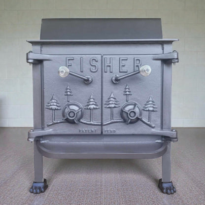 Gray cast iron stove with 'Fisher' branding on a neutral background